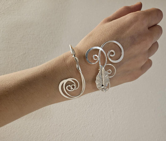 Sterling silver-plated elven wrap bracelet with intricate leaf detail shown worn on a wrist to demonstrate the adjustable fit.