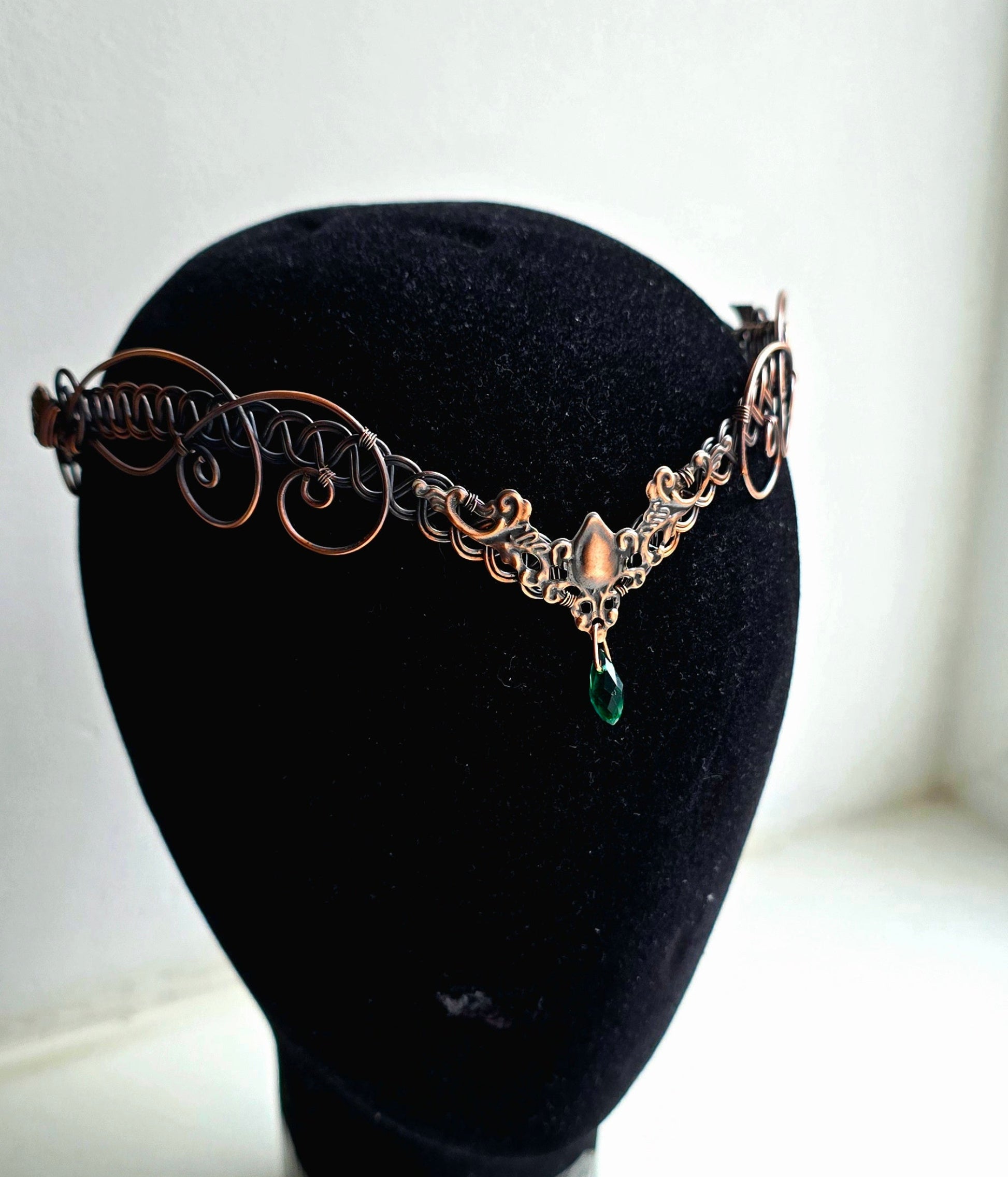 Decorative headband on a black mannequin head against a white background