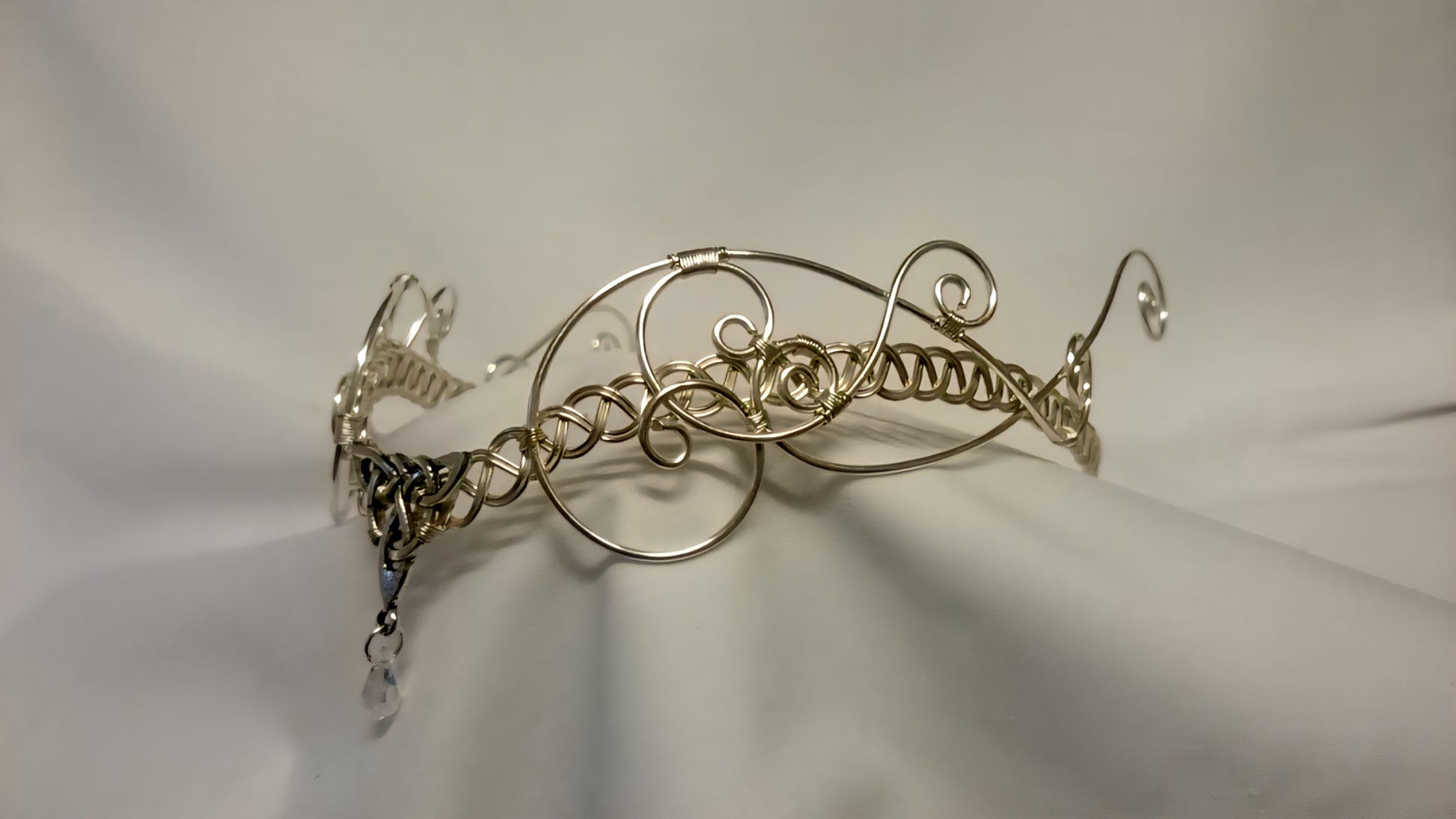Handcrafted silver-plated Celtic tiara for handfasting, featuring a triquetra knot and iridescent AB crystal on a soft white background.